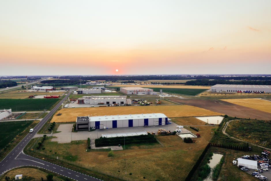 Aerial view of industrial warehouses in Poznań, Poland at sunrise, showcasing the landscape and architecture.