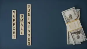 Conceptual image of supporting small businesses with financial resources using money and letter tiles.