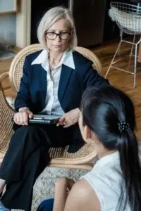 A serious discussion between two businesswomen in a modern office environment.