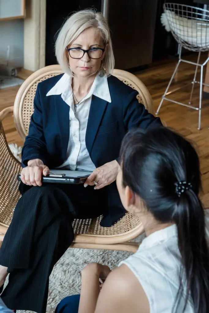 A serious discussion between two businesswomen in a modern office environment.